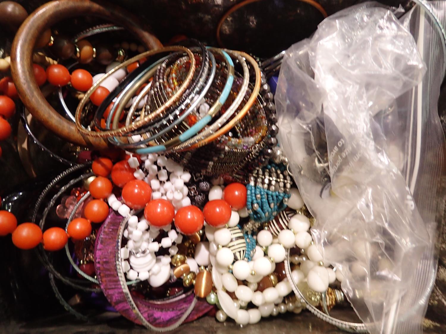 Lidded box containing unsorted costume jewellery mainly bangles. P&P Group 2 (£18+VAT for the