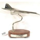 Chrome Concorde on wooden base, wingspan 10 cm. P&P Group 1 (£14+VAT for the first lot and £1+VAT