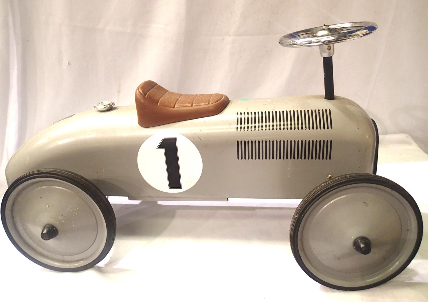 Childs push along, sit on silver racing car with steaming wheels. Approximately 75 cm and long