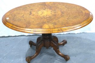 A 19th century burr walnut oval breakfast table, inlaid with tilting top and carved quadripartide