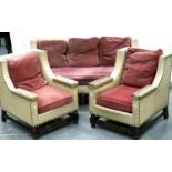 An early 20th century oak framed cream leather three piece lounge suite, with brass studs and pink