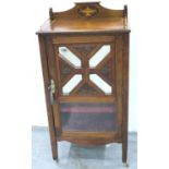 An Edwardian walnut music cabinet, the single door with mirrored panels, the interior shelves velvet