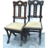 A pair of Victorian gothic style hall chairs, with pierced back rests and studded upholstered seats,