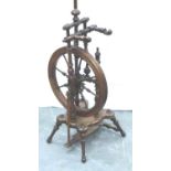 An early 19th century European fruitwood tredle spinning wheel of small proportions with turned