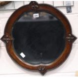 A Victorian oak framed wall mirror, having shaped and bevelled glass, overall 60 x 60 cm. Not