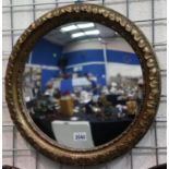 A 19th century convex circular wall mirror with a gilt carved wood frame, overall D: 50 cm. Not