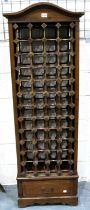 A contemporary stained pine wine rack for 48 bottles, with single drawer below, 57 x 37 x 169 cm