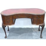 A reproduction walnut kidney shaped Bonheur du Jour with tooled red leather inset top and five