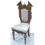 A 19th century mahogany hall chair, heavily carved with broken pediment and figurehead, for