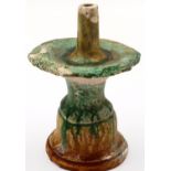 A Ming Dynasty glazed white clay taper stand, having a pricket with drip tray supported on a bell