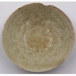 A celadon glazed porcelain bowl having incised decoration to its interior and a footed base, D: 17