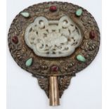 An 18th century silver hand mirror, set with semi-precious stones and a large carved celadon jade