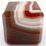 A heavily banded polished chuyu red agate cube, having chamfered edges, 5 x 5 x 5 cm. P&P Group