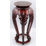 A 20th century cherrywood vase stand, having simplistic carved frieze and lotus form top, H: 61