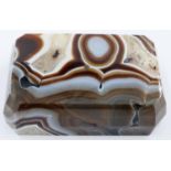 A large laced and heavily banded manao brown agate block, 13 x 8 x 3.5 cm H. One small chip to the
