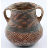 A Neolithic period painted terracotta twin handled pot, decorated with geometric designs, H: 10