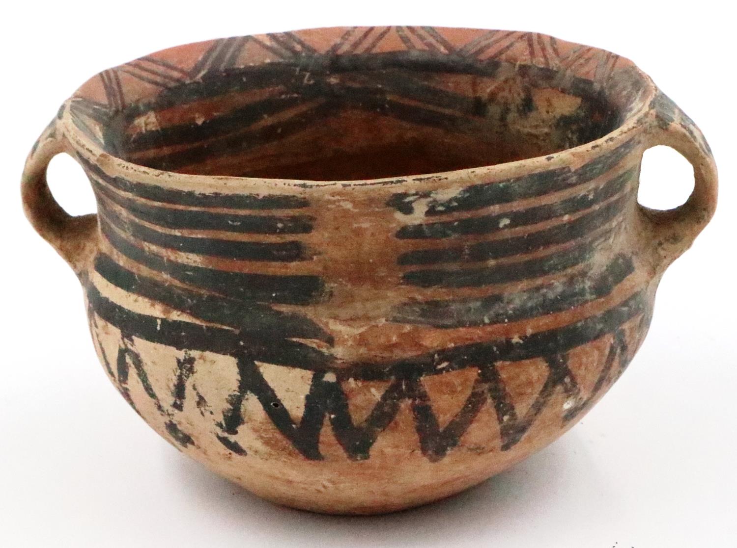 A Neolithic period painted terracotta twin handled pot, decorated with geometric designs, repaired