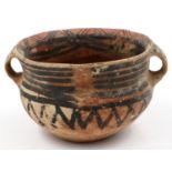 A Neolithic period painted terracotta twin handled pot, decorated with geometric designs, repaired