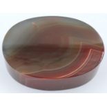 A banded oval block of chuyu red agate, 9 x 7 x 2 cm H. P&P Group 2 (£18+VAT for the first lot