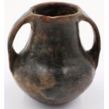 A Han Dynasty black pottery amphora vessel, the body stylised with twin handles, H: 13 cm. Crack