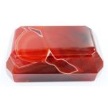 A banded and polished chuyu red agate block, with bevelled edges and of tapering form, 9 x 5.5 x 3