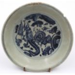 A Ming Dynasty glazed shallow bowl, with a painted circular panel depicting a dragon amongst clouds,