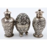 Two export silver pepperettes of typical design, together with an egg form silver pepperette,