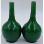 A pair of glazed bottle vases, of diminutive proportions in deep apple green, each H: 15 cm. Some