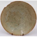 A celadon glazed porcelain bowl having incised decoration to its interior and a footed base, D: 17