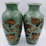 A pair of celadon glazed vases, each decorated with enamels and gilt with lotus flowers against