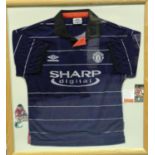 Framed Manchester United Football Club blue Umbro shirt, Sharp, signed by George Best, 78 x 86 cm.