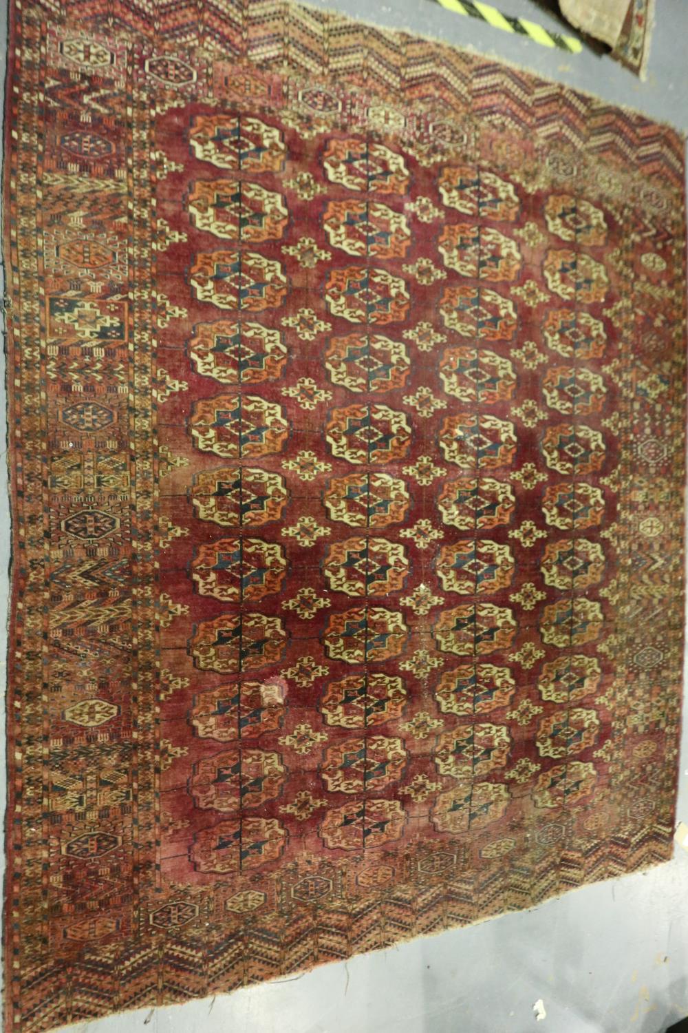 A large Persian knotted floor rug, red ground with complex geometric designs, 255 x 215 cm. Not