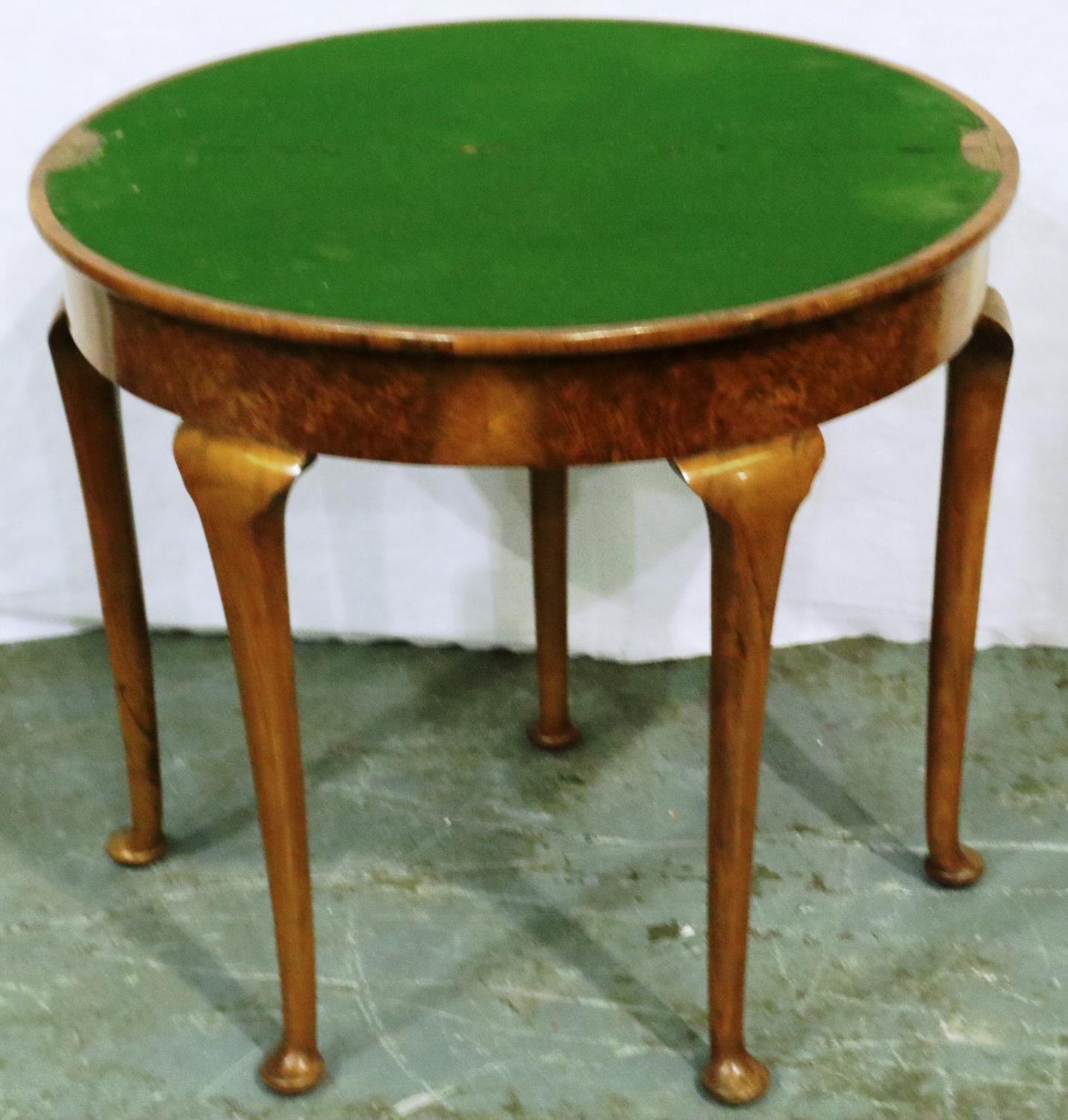 An early 20th century walnut demi-lune games table with fold over top and cabriole supports, D: 84