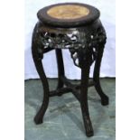 An early 20th century Oriental vase stand with a heavily carved base and rouge marble inset top,