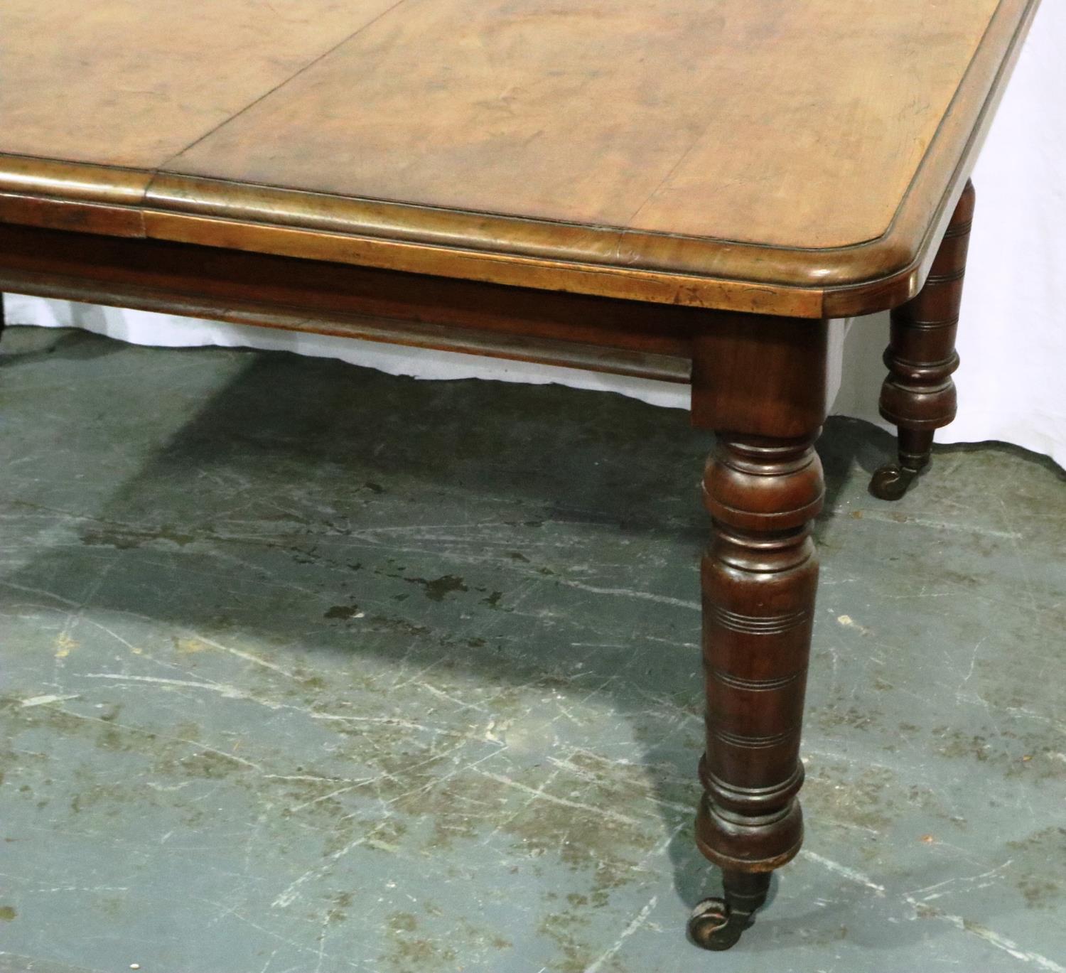 A Victorian walnut wind out extending dining table having one additional leaf and turned supports, - Image 3 of 3