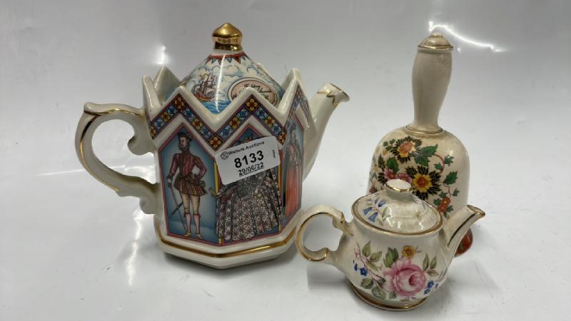 TWO ORNAMENTAL TEAPOTS AND A BELL