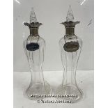 A PAIR OF ANTIQUE GLASS WHISKEY AND SHERRY DECANTERS WITH STERLING SILVER TOPS AND BADGES AND