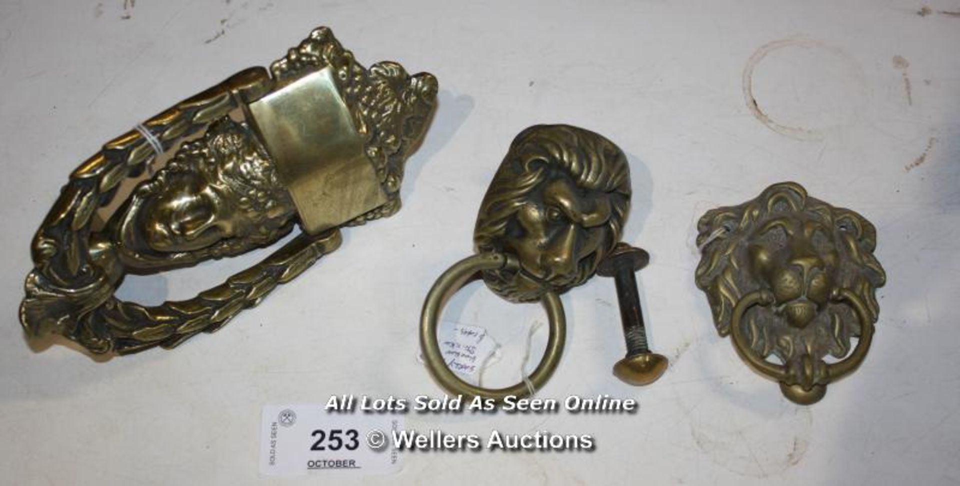 THREE BRASS DOOR KNOCKERS, TWO WITH LION HEADS