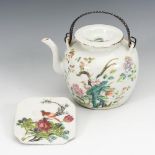 Teekanne und Porzellanplatte mit Vögeln und Blumen.