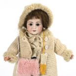 Kleine Mädchenpuppe in Winterkleidung.
