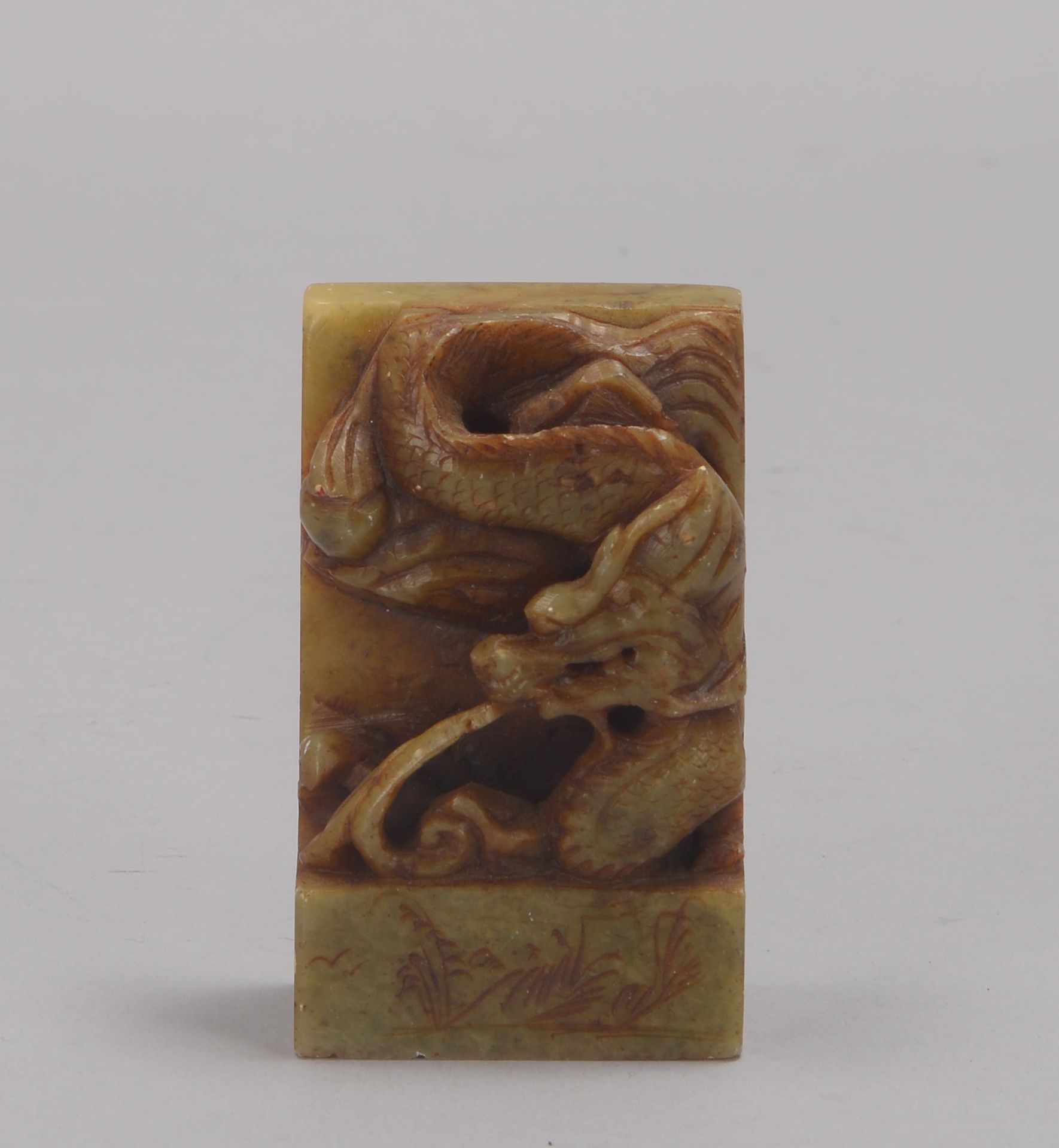 Siegelstempel (China), wohl Serpentin, umlaufend mit halbplastischer Figurenapplikation ('Drache'); 