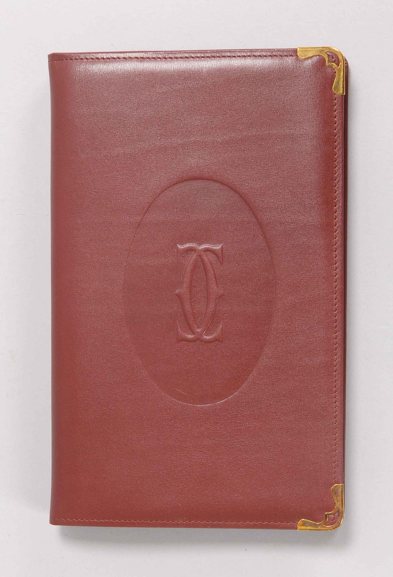 Cartier, Adressbuch, Einband burgund-rotes Rindsleder, im original Karton; Maße 22 x 14 cm