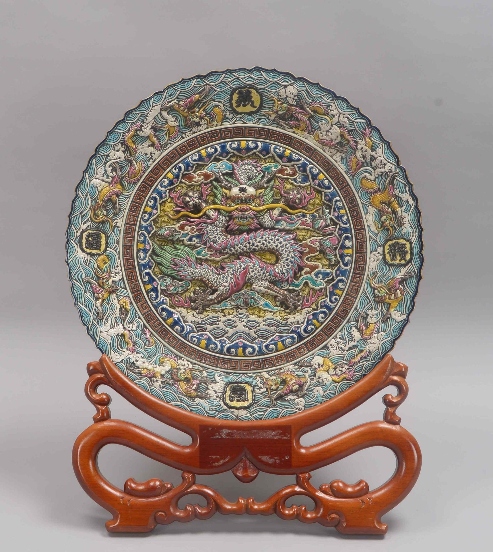 Prunkteller (China, 20. Jahrhundert), wohl Wucai-Keramik, mit polychromem Reliefdekor: Spiegel mit s