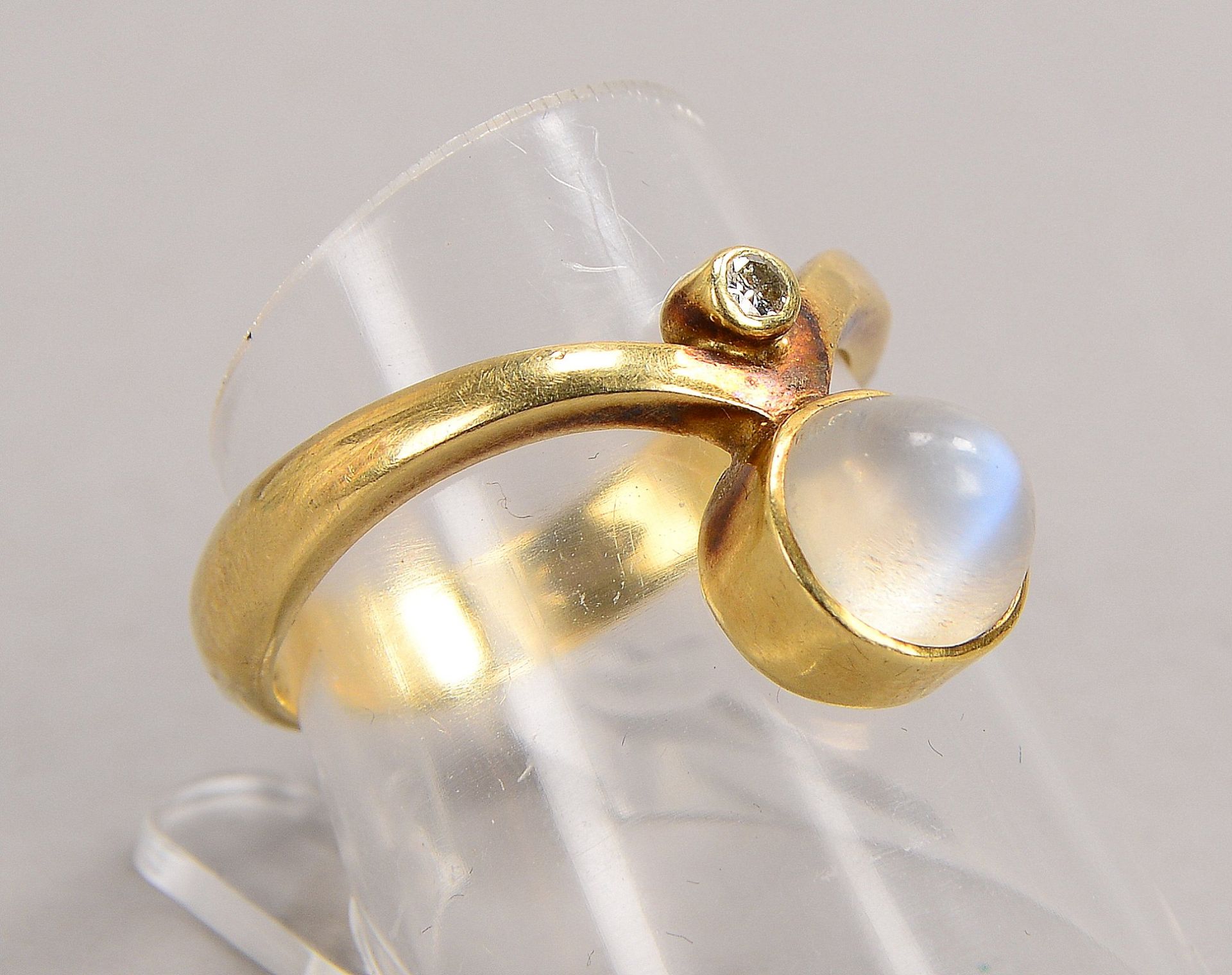 Ring, 585 GG (gestempelt), besetzt mit einzelnem kleinem Brillant und einzelnem Mondsteincabochon; R