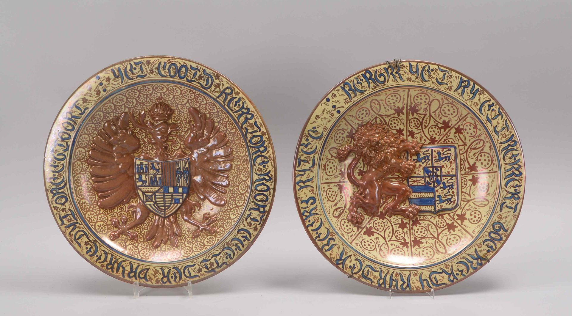 2 Wappenteller, antik, farbig gefasst, im Spiegel mit Wappenmotiv sowie stark reliefiertem Löwen-/Ad