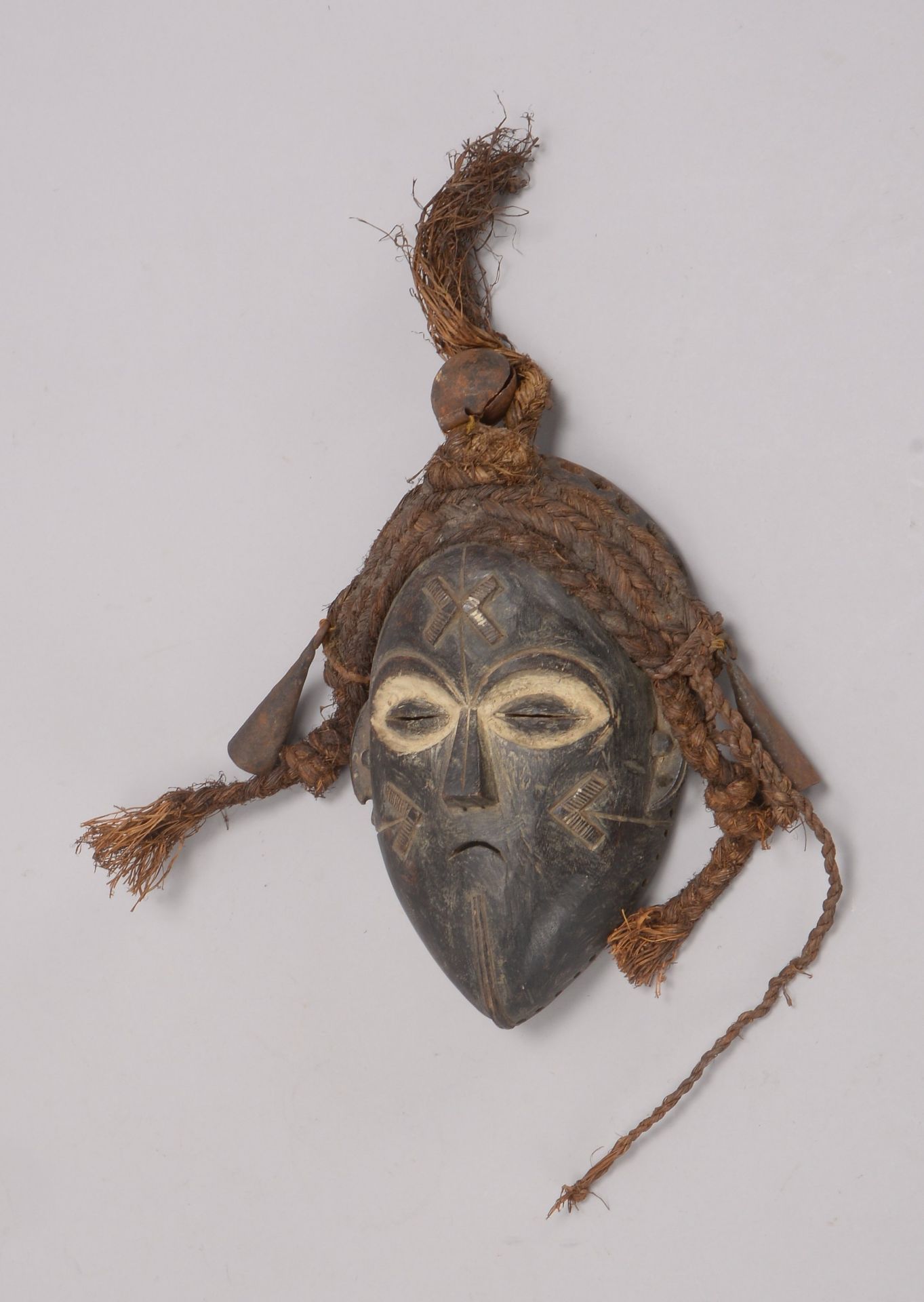 Holzmaske (Afrika), Holz teils wei&szlig; gefasst/teils reliefiert, mit Rattanbesatz und Glockenbeha