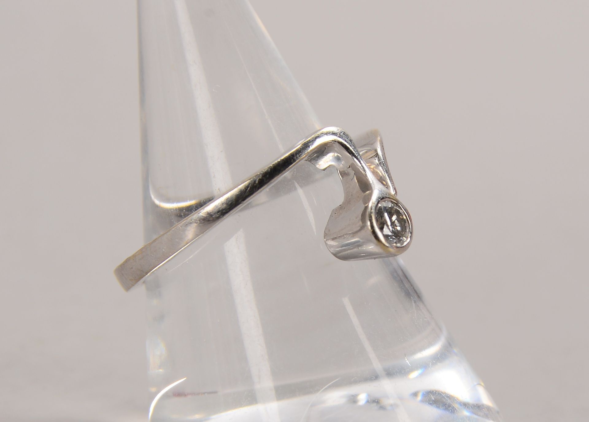 Ring, 585 WG (gestempelt), besetzt mit einzelnem Brillant von 0,12 ct; RG 48, Gewicht 2,40 g