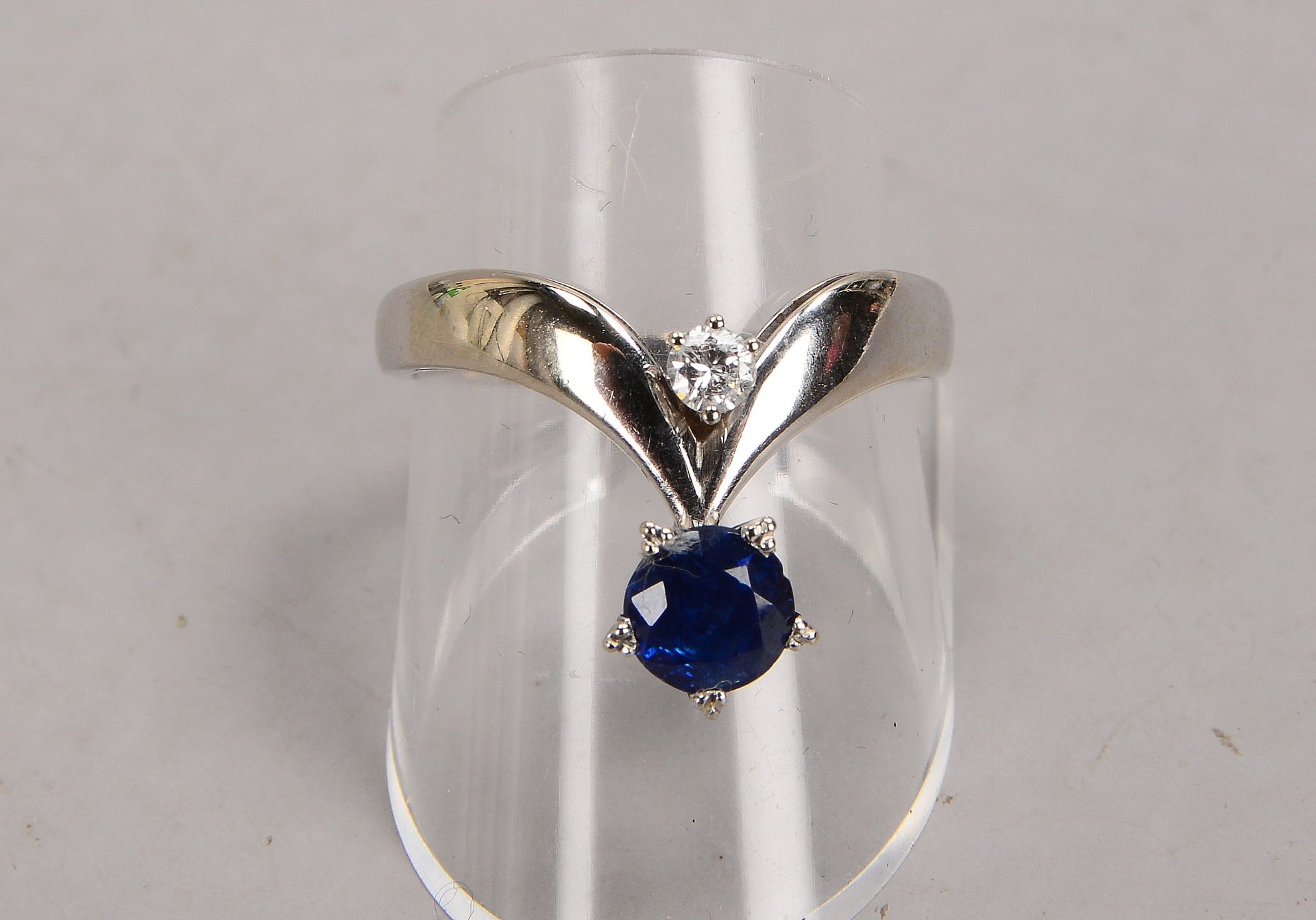 Ring, 750 WG (gestempelt), besetzt mit je einzelnem kleinem Brillant von ca. 0,10 ct, und Saphir
