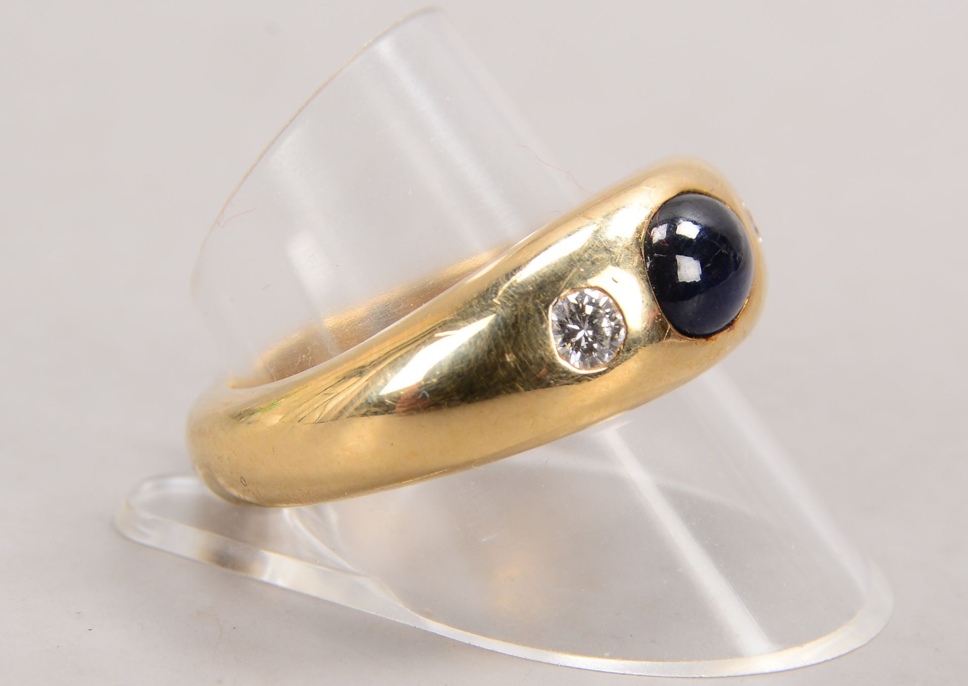Ring, 585 GG (gestempelt), besetzt mit einzelnem Saphir, Stein im Cabochonschliff, und 2x Brillanten