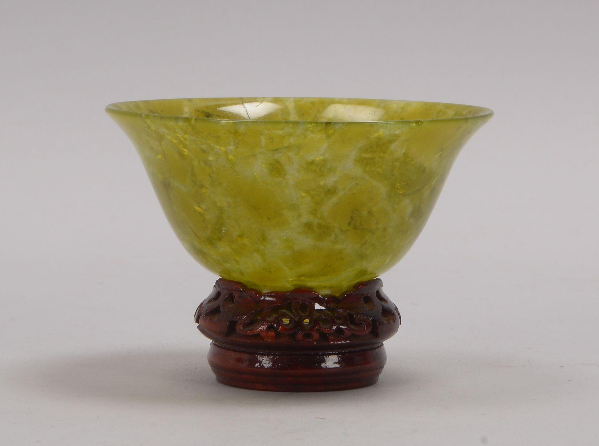 Schale (China), grüne Jade, mit leicht aufgestelltem Rand, auf schmalem Standring, auf Holzsockel